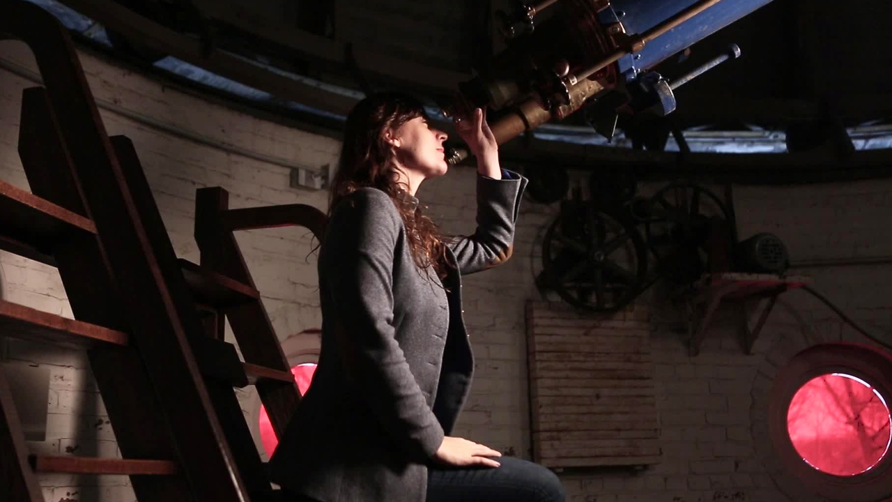 Lisa Kaltenegger looking through a telescope