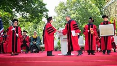 Martha Pollack and Robert Harrison shake hands during the installation ceremony