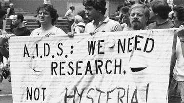 people hold banner that reads AIDS: We Need Research, Not Hysteria