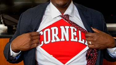 Kevin Boothe pulls open his button down shirt to reveal a red Cornell shirt underneath