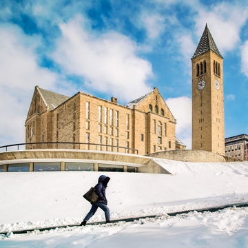 A students walks up a snow-covered Libe Slope at Cornell University 