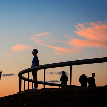 Students view a pink and blue sunset on the slope overlook