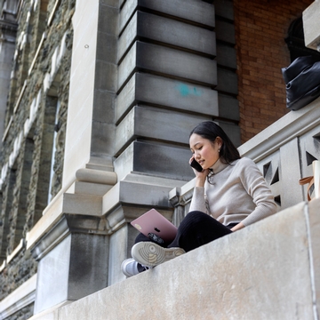 一个学生坐在西伯利亚大厅外面