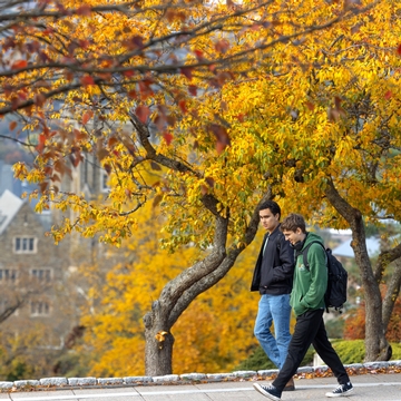 Two students walking in fall.