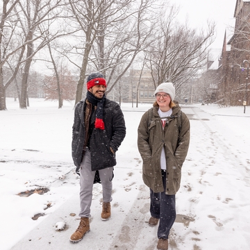 Two students walking in the snow. 