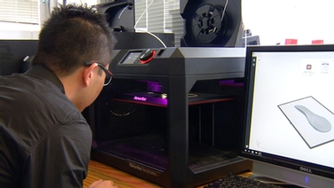student watches 3-d printer