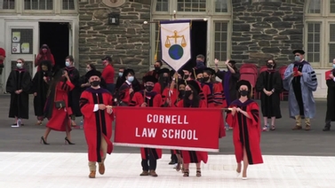 Law School graduates carry the college banner.