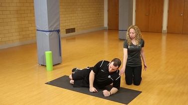 Kerry and TJ, exercise physiologists from Cornell Wellness, demonstrate a stretch