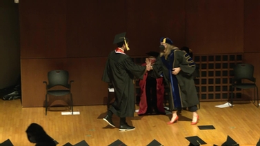 A graduate receiving a diploma. 