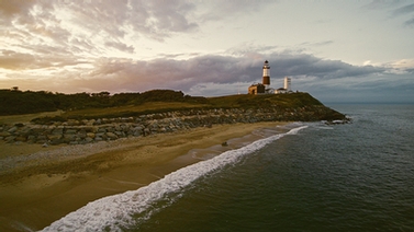 shoreline with lighthouse in the background