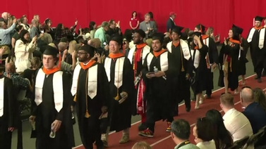 Graduates walk into the auditorium.