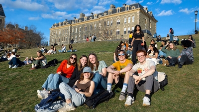 A group of students smiling and enjoying a sunny day on Libe Slope.