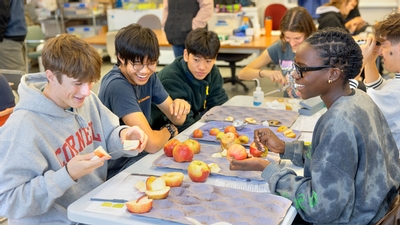 A group of students smiling with apples. 