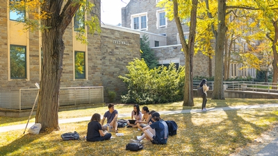 A group of students sit outside 